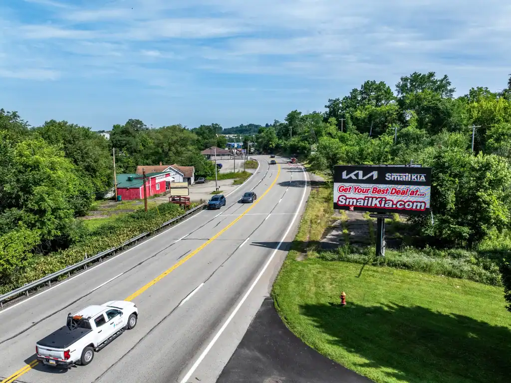A digital Penneco Outdoor Advertising billboard featuring a car dealership sits along a highway in Westmoreland County, PA