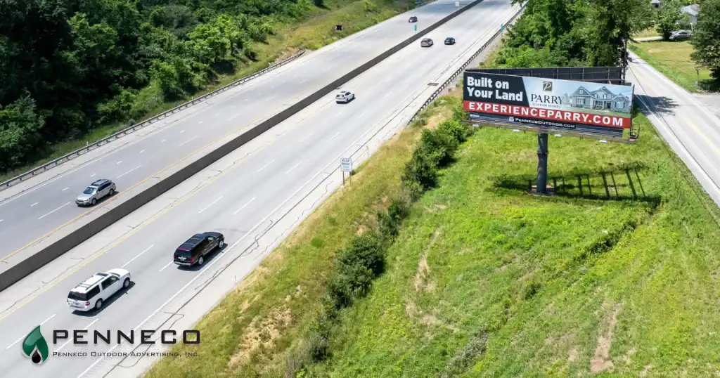 a Penneco Outdoor Advertising billboard sits along a busy Western Pennsylvania highway